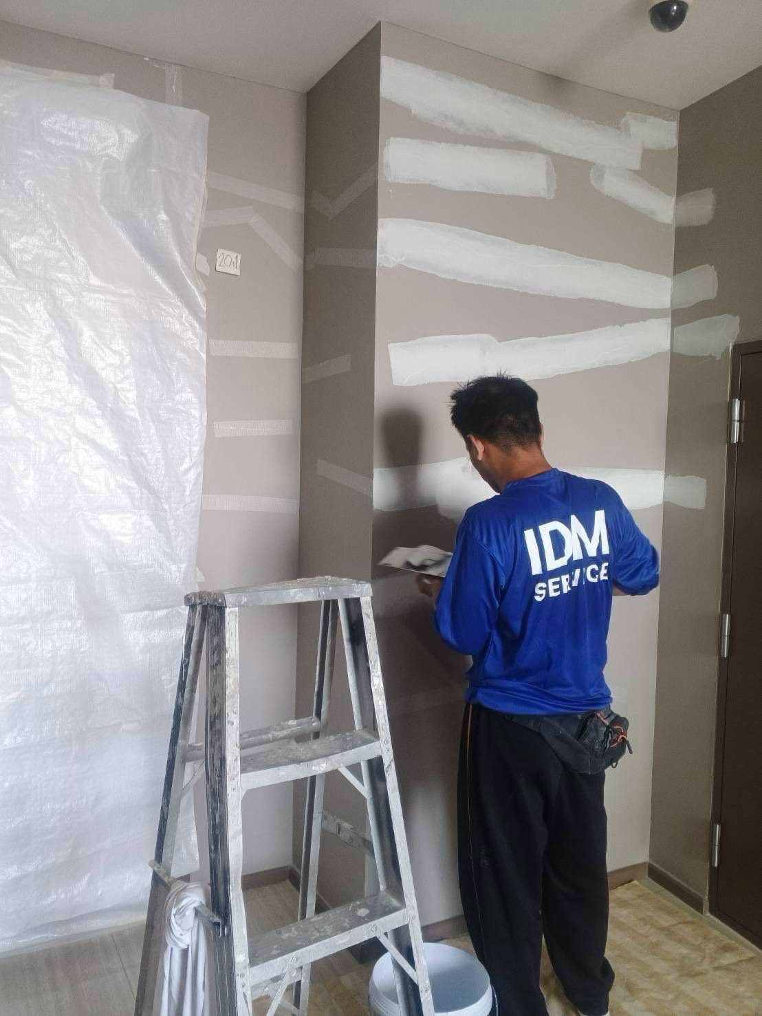 ช่าง IDM Service ฉาบแต่งผิวผนังห้องพักหลังซ่อมรอยร้าวหลายแนว