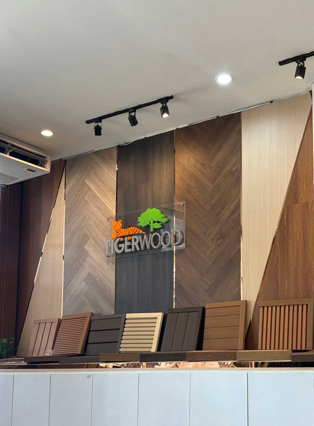ผนังจัดแสดงพื้นไม้ TIGERWOOD ลายก้างปลาและตัวอย่างไม้ผนัง ในโชว์รูม IDM Premium Outlet